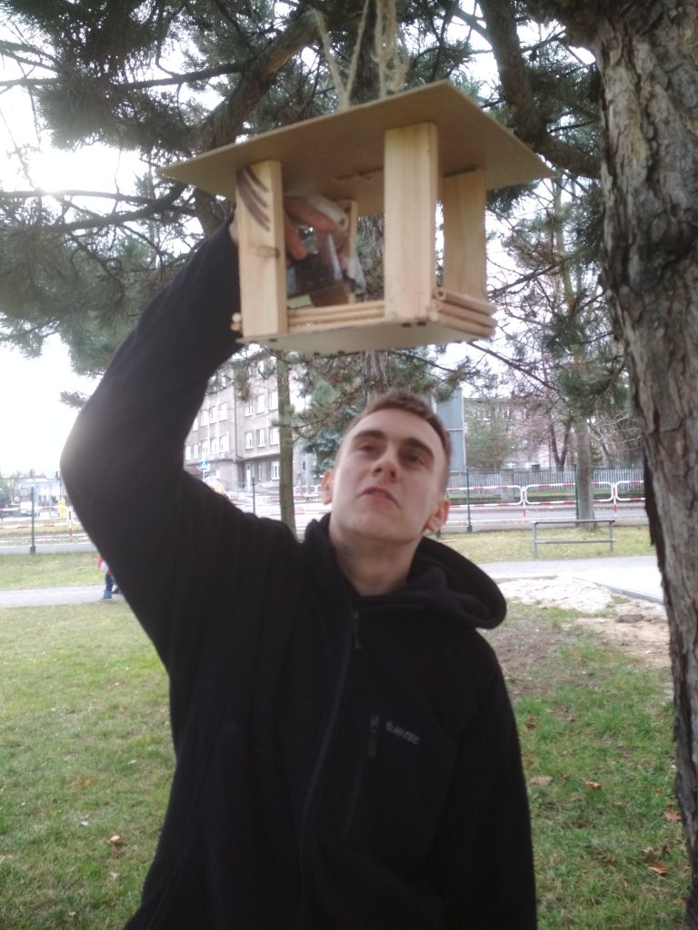 uczniowie sypią słonecznik do karmnika