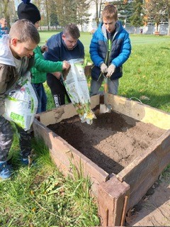 uczniowie pracują na grządkach