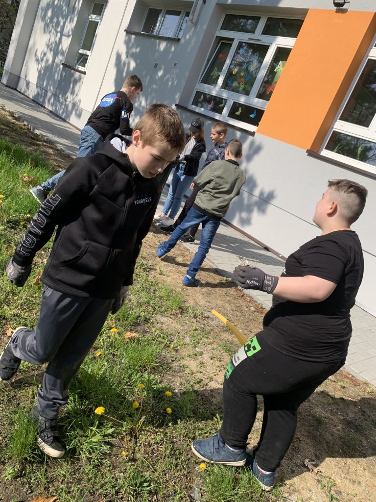 uczniowie sprzątają teren szkoły