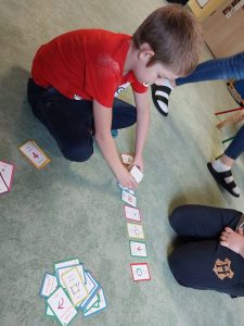 Chłopczyk koduje robota poruszając się po kartach