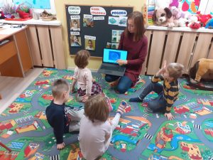 Pani nauczycielka opowiada o fladze Unii Europejskiej i znaczeniu jej gwiazd