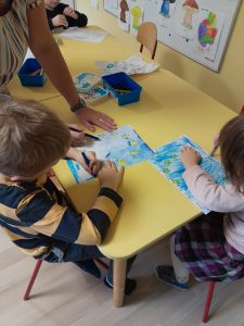 Dzieci kolorują pracę plastyczną