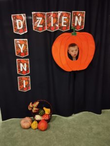 Chłopczyk pozuje do zdjęcia z dynią