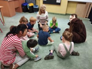 Dzieci bawią się w kółeczku z kundelkiem