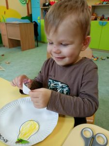 Chłopczyk robi pracę plastyczną