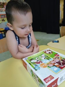 Chłopczyk bawi się zabawką puzzlami