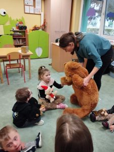 Dzieci siedzą w kółeczku z nauczycielką