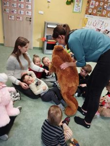 Dzieci siedzą w kółeczku z nauczycielkami