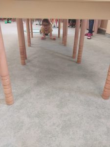 chłopiec wchodzi pod stoliczki