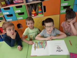 chłopcy przeglądają książkę z potworem