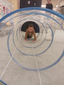 chłopiec wchodzi na czworaka do tunelu