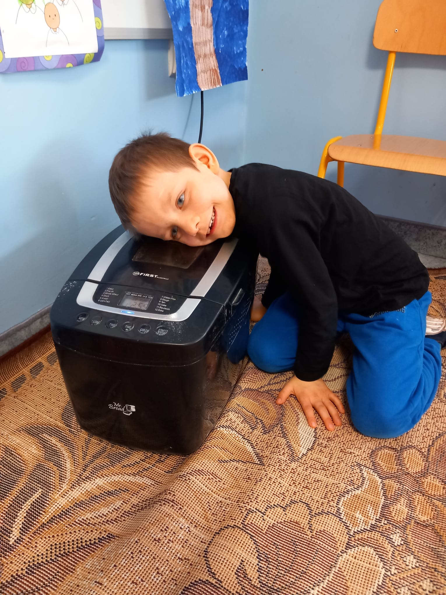 Chłopczyk słucha jak ciasto się wyrabia w maszynie