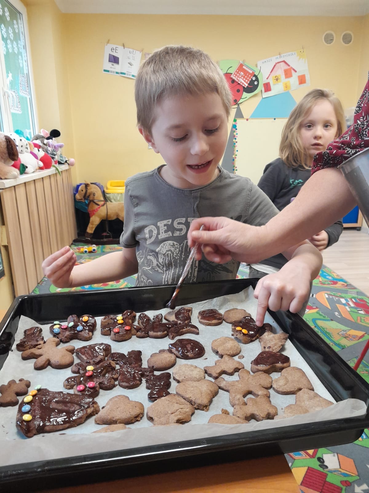 Chłopczyk dekoruje ciasteczka