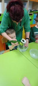 chłopiec szatkuje ogórka przy pomocy pani