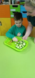 Chłopczyk kosztuje plaster ogórka