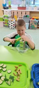 Chłopczyk szatkuje ogórka