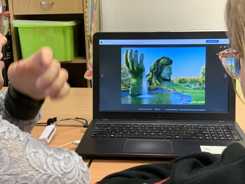 uczniowie podziwiają ogrody świata na komputerze