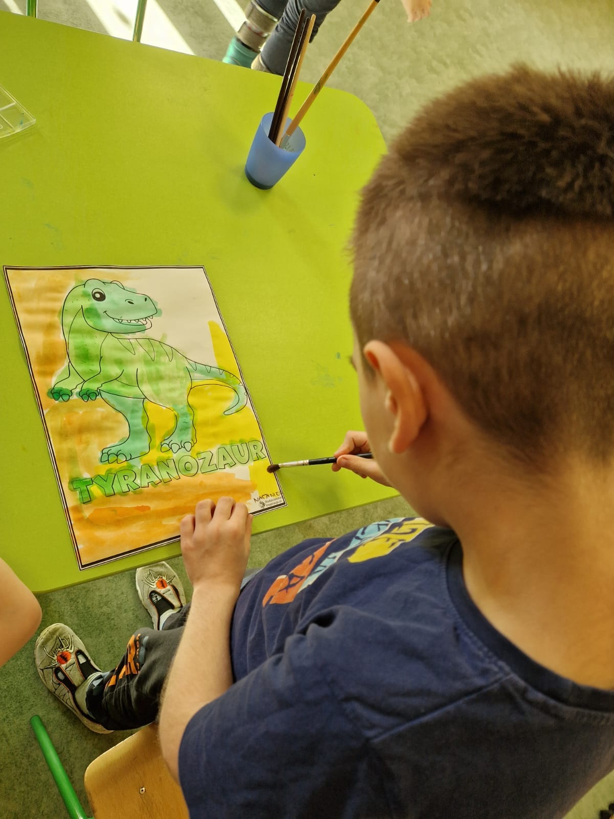 chłopiec maluje dinozaury