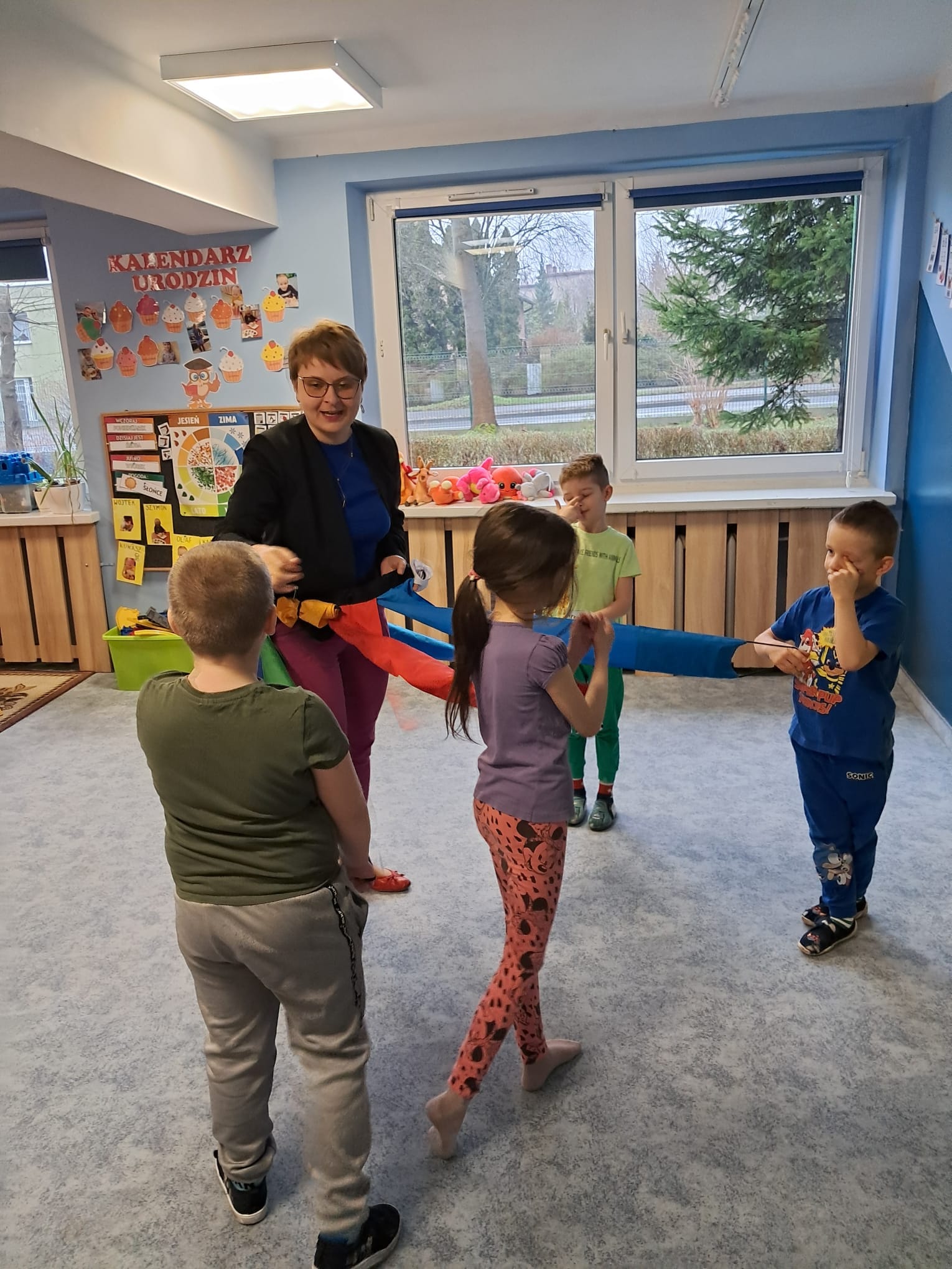 Dzieci bawią się wiatrakiem matematycznym wraz z panią