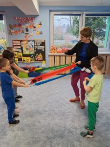 Dzieci bawią się wiatrakiem matematycznym wraz z panią