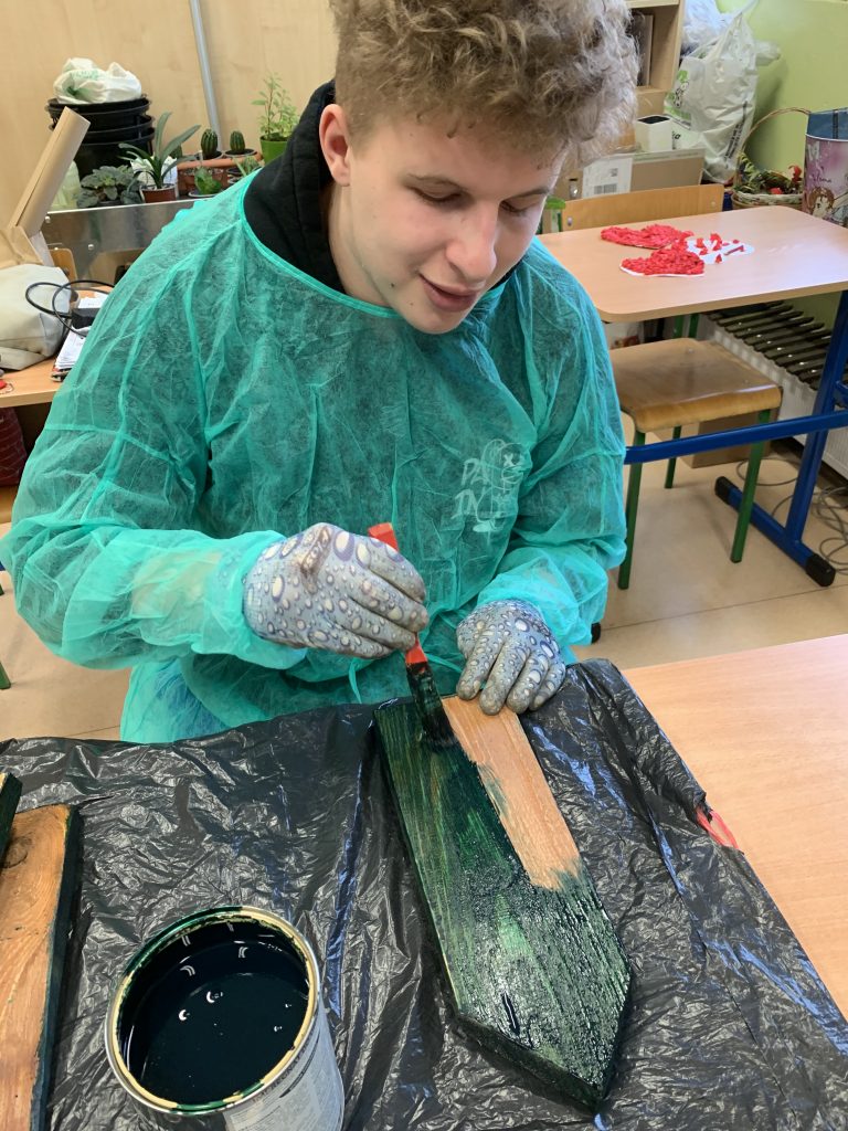 w lutym uczniowie malują drewniane elementy na dekorację do szkolnego ogrodu