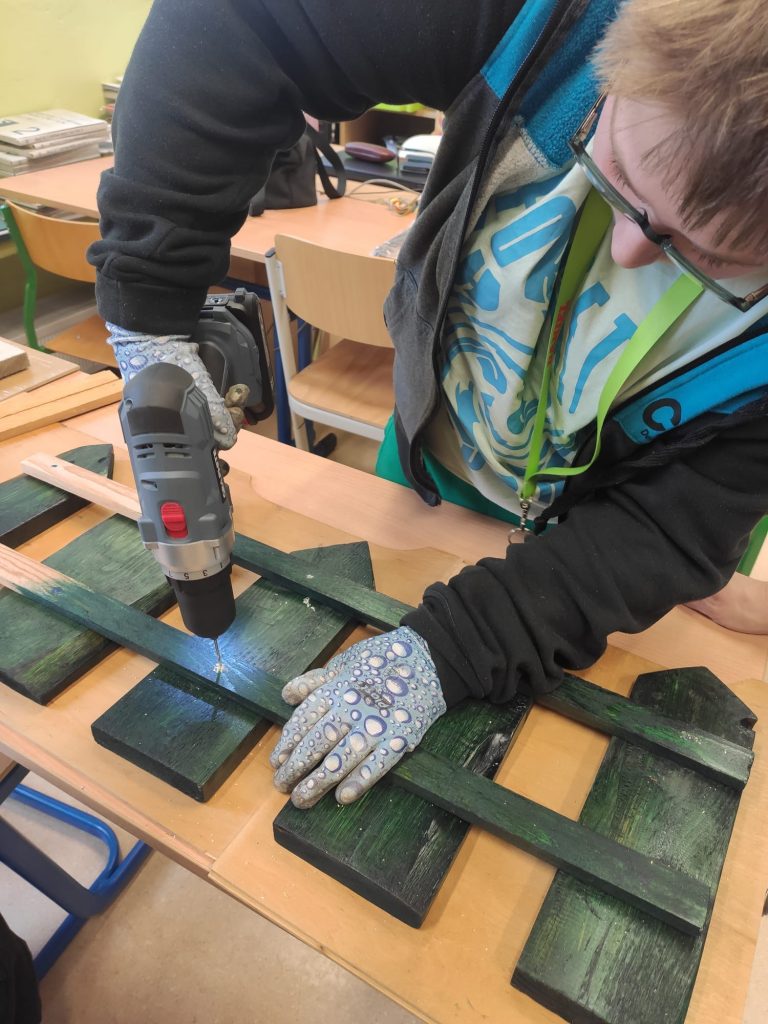 uczniowie uczą się korzystać ze szkolnej wiertarki z projektu Laboratorium Przyszłości