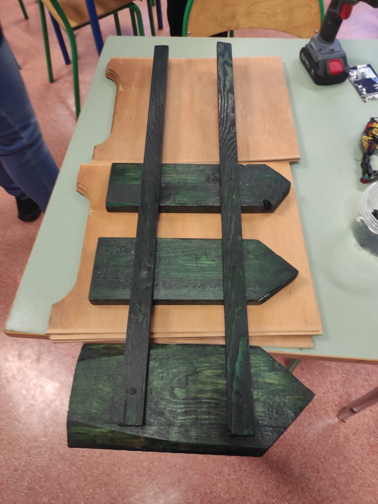 uczniowie skręcają drewniane elementy na dekorację do szkolnego ogrodu