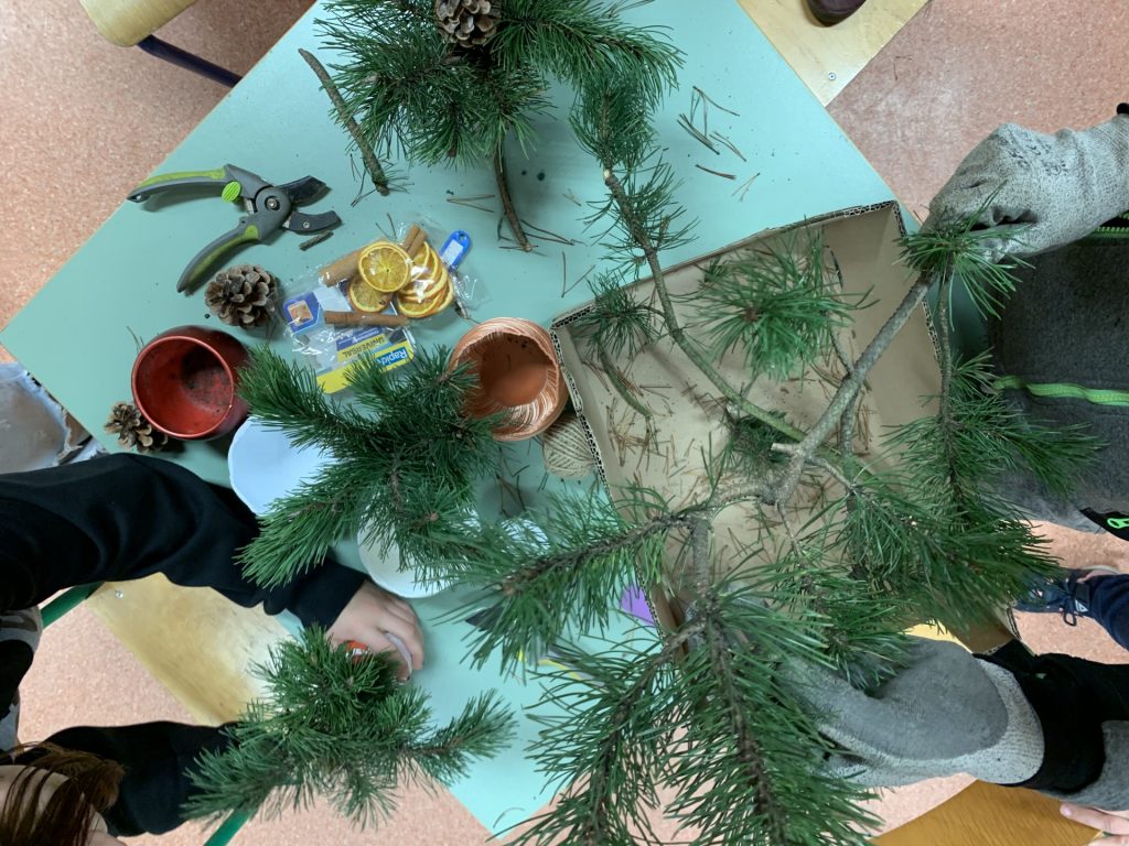 uczniowie przygotowują świąteczne stroiki