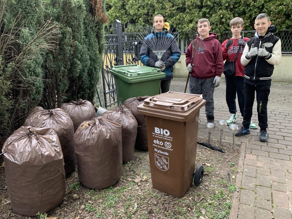 uczniowie pomagają w pracach porządkowych w ogrodzie